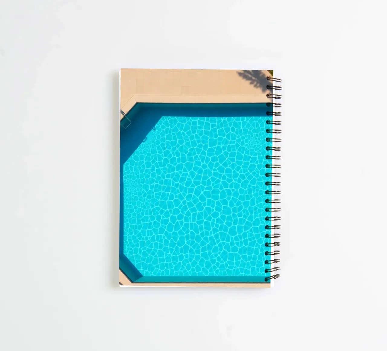 Bright blue swimming pool surrounded by a sunny patio spiral notebook by DesignDoodle