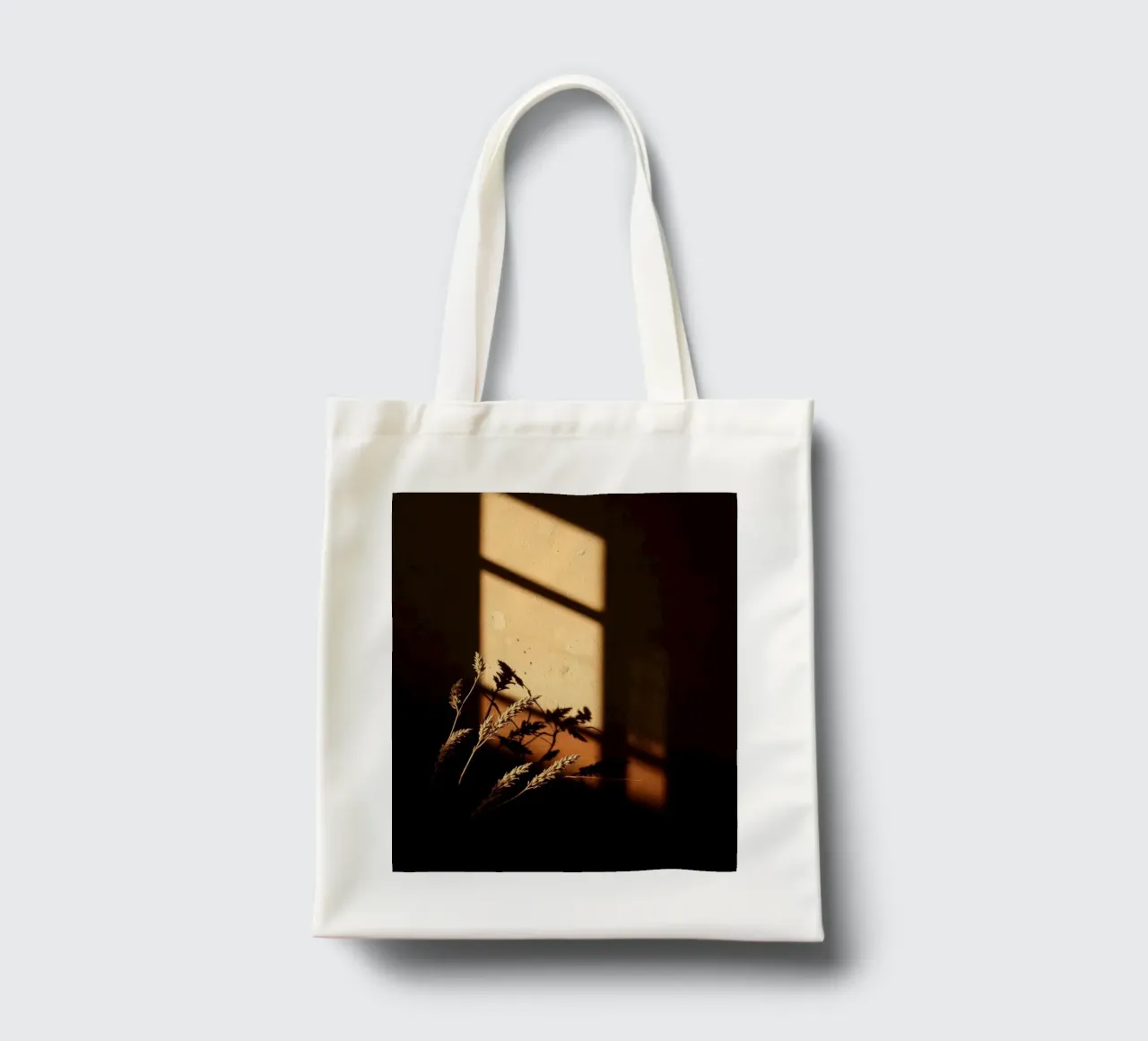 Warm sunlight casts shadows of dried plants tote bag by DesignDoodle