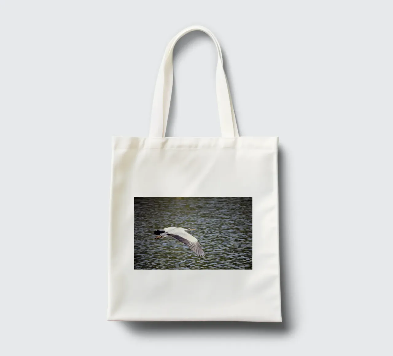 Héron en vol au-dessus de l'eau tote bag de Jack C Photography