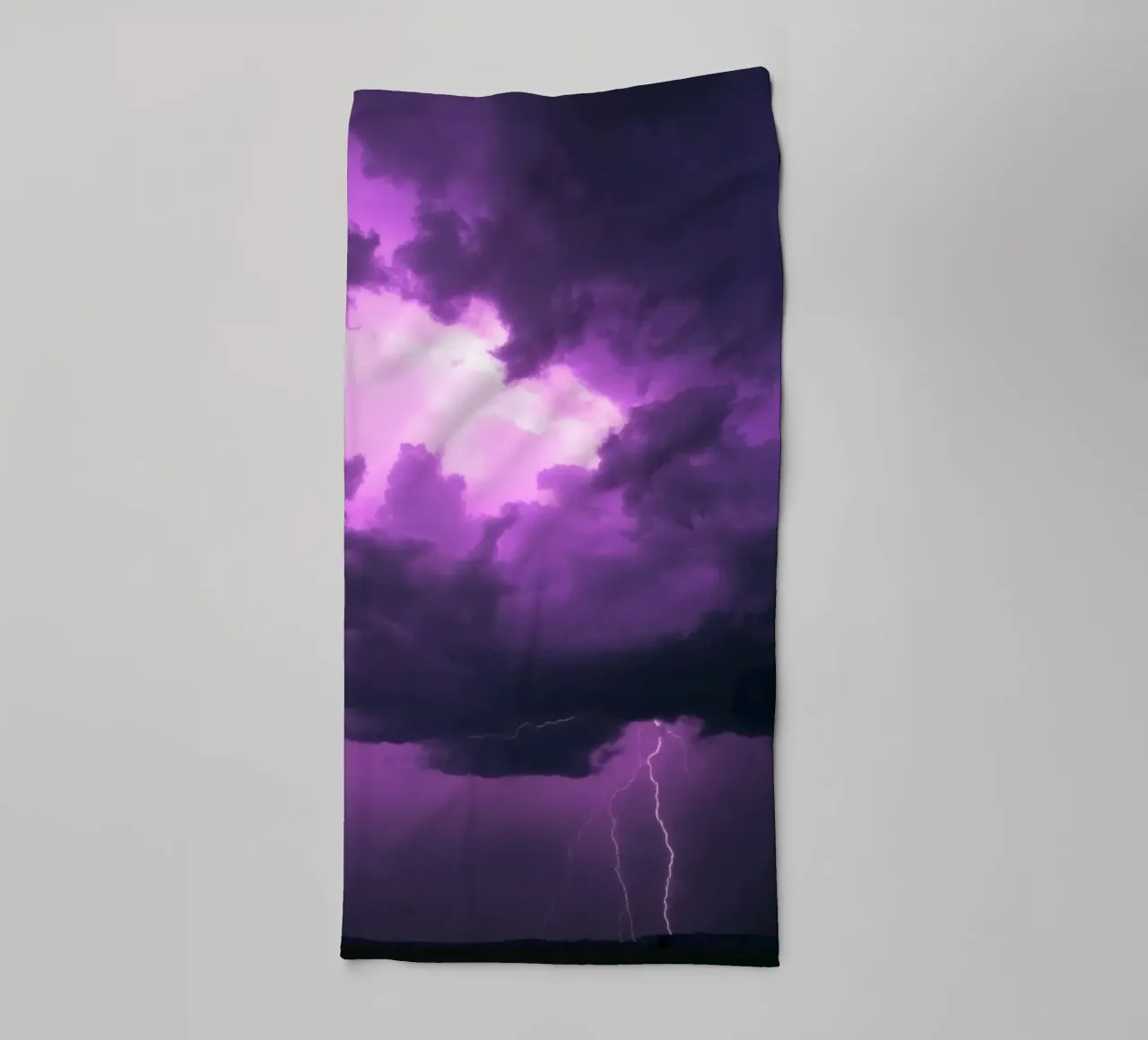 Dramatic lightning strikes illuminate a purple stormy sky towel by DesignDoodle