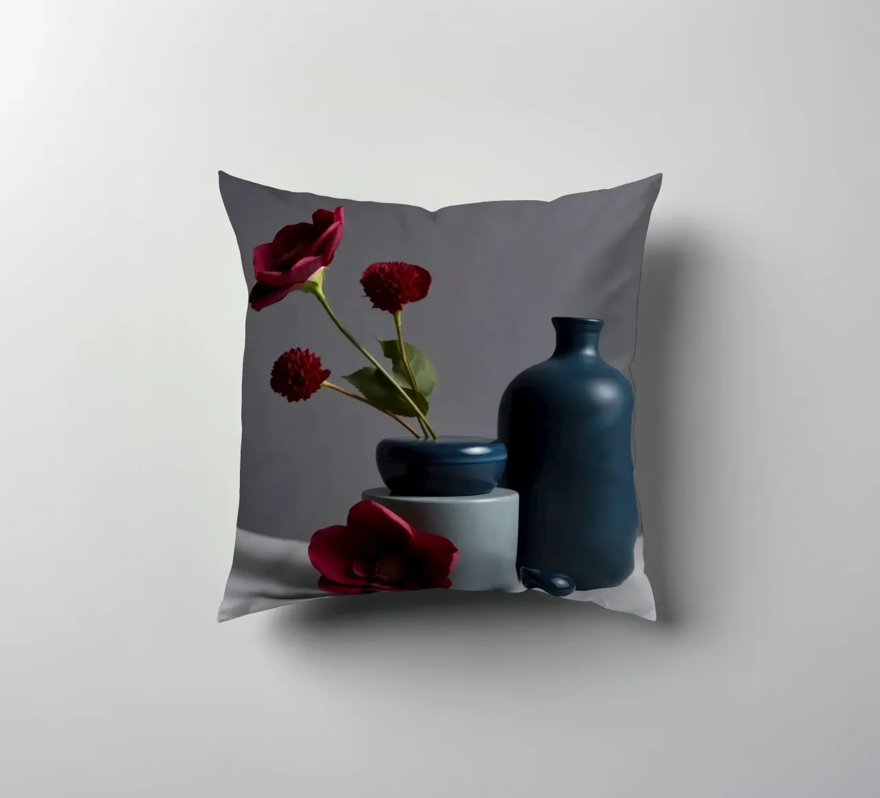 vasi blu scuro con fiori vivaci su un tavolo minimalista cuscino da DesignDoodle