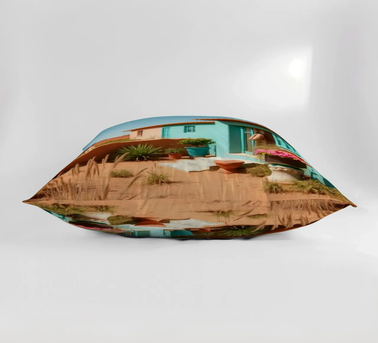 Casa dai colori vivaci con giardino in un soleggiato paesaggio desertico cuscino da DesignDoodle