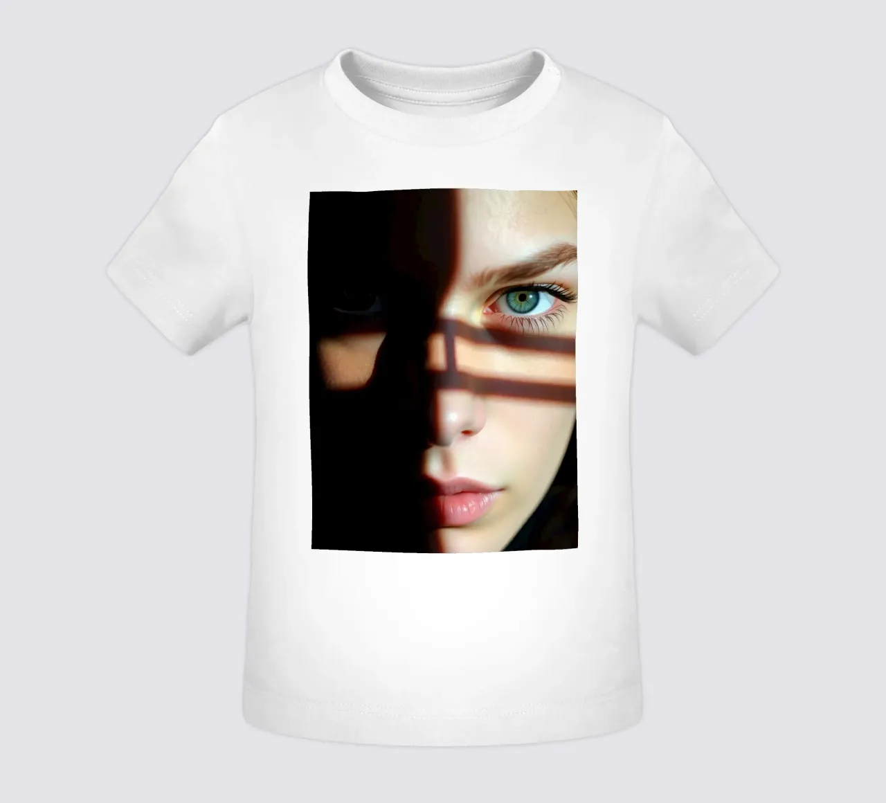 Ragazza con suggestivi occhi verdi parzialmente illuminati dallo shado maglietta neonato da DesignDoodle