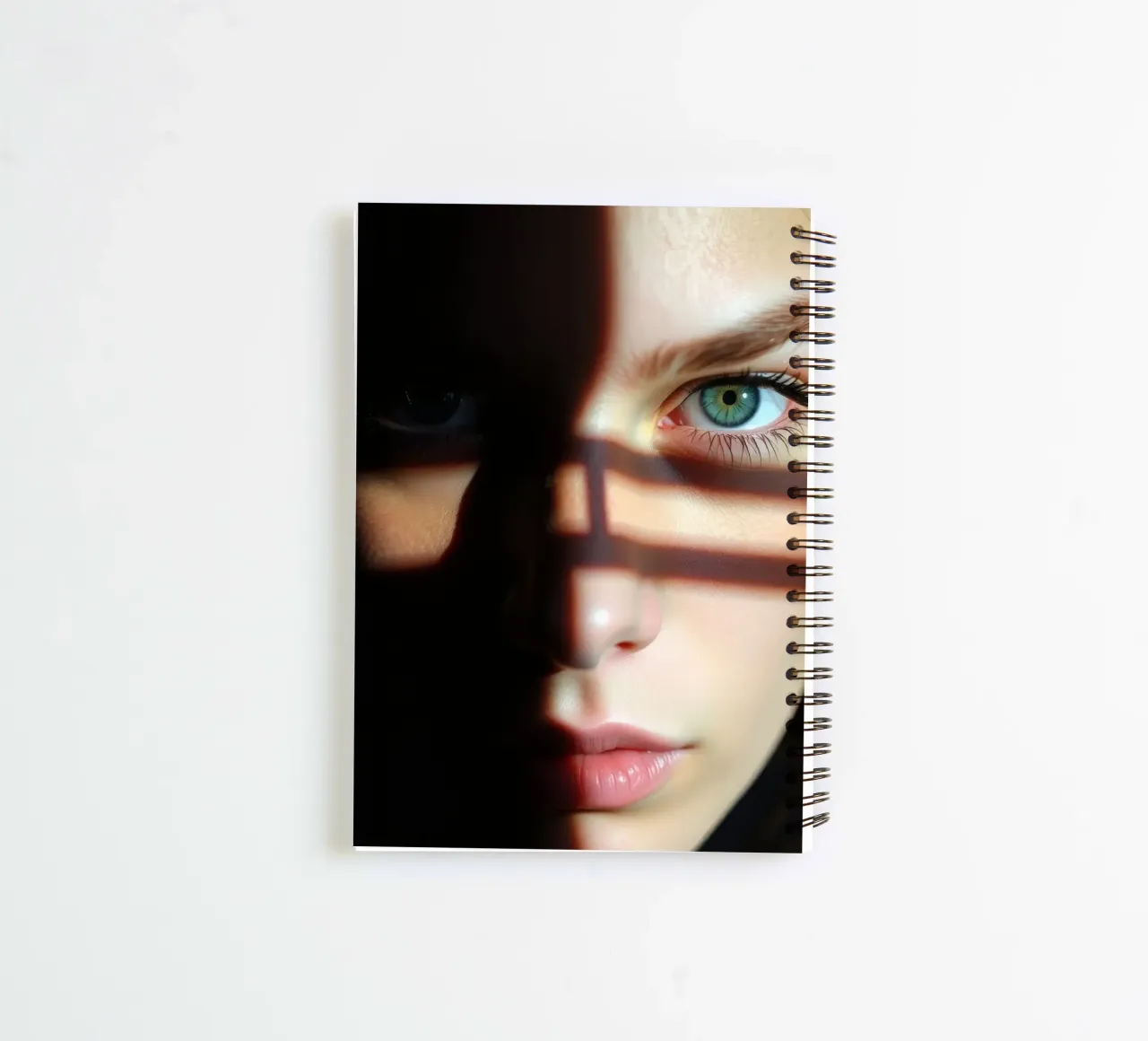 Girl with striking green eyes partially illuminated by shado spiral notebook by DesignDoodle