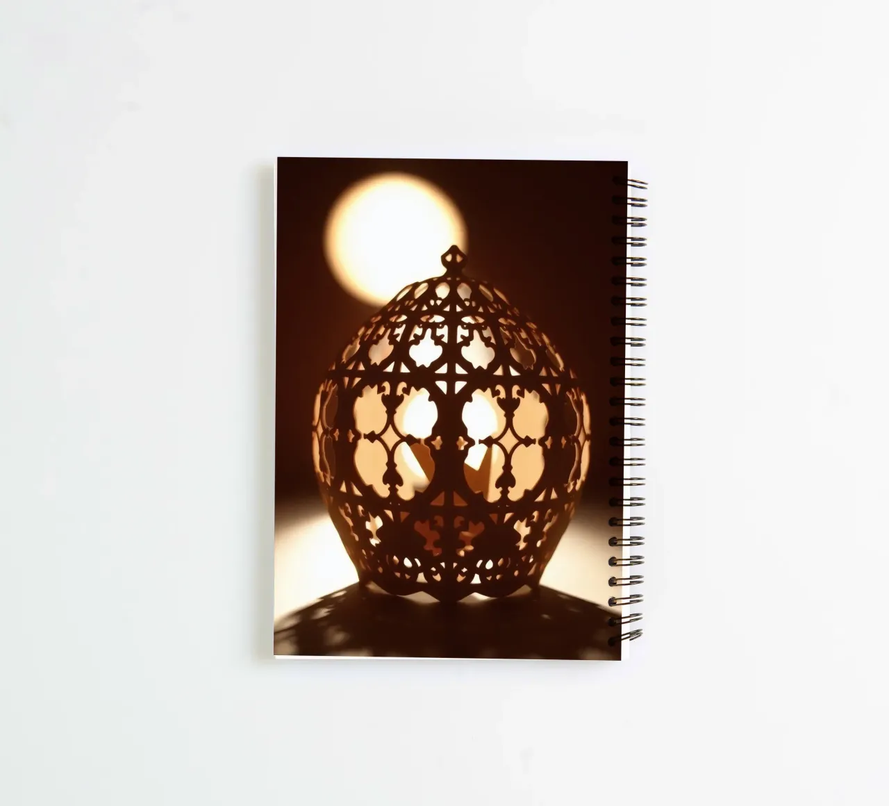 Intricately designed lantern casting warm light at sunset spiral notebook by DesignDoodle