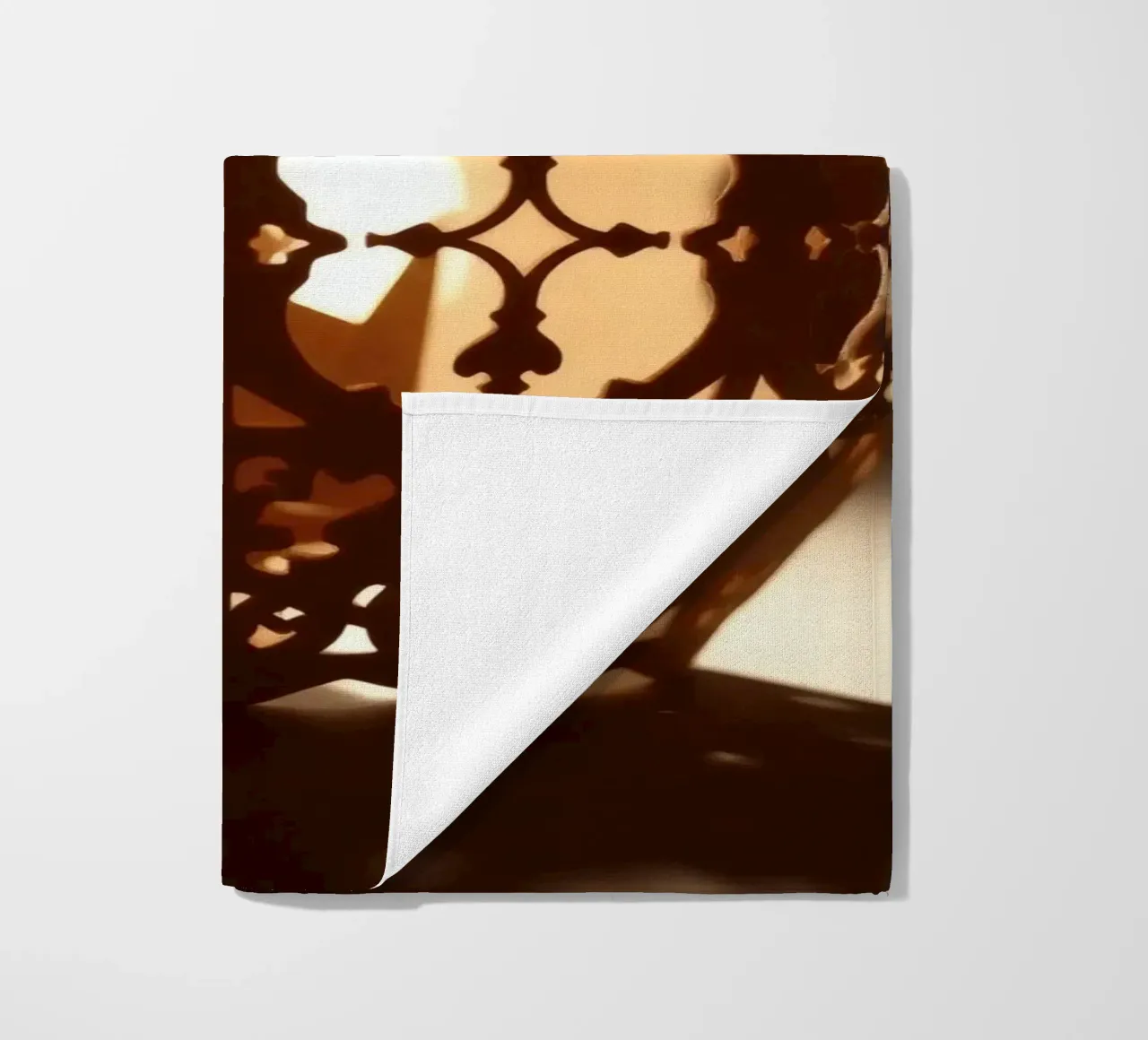 Lanterna dal design complicato che proietta una luce calda al tramonto telo mare da DesignDoodle