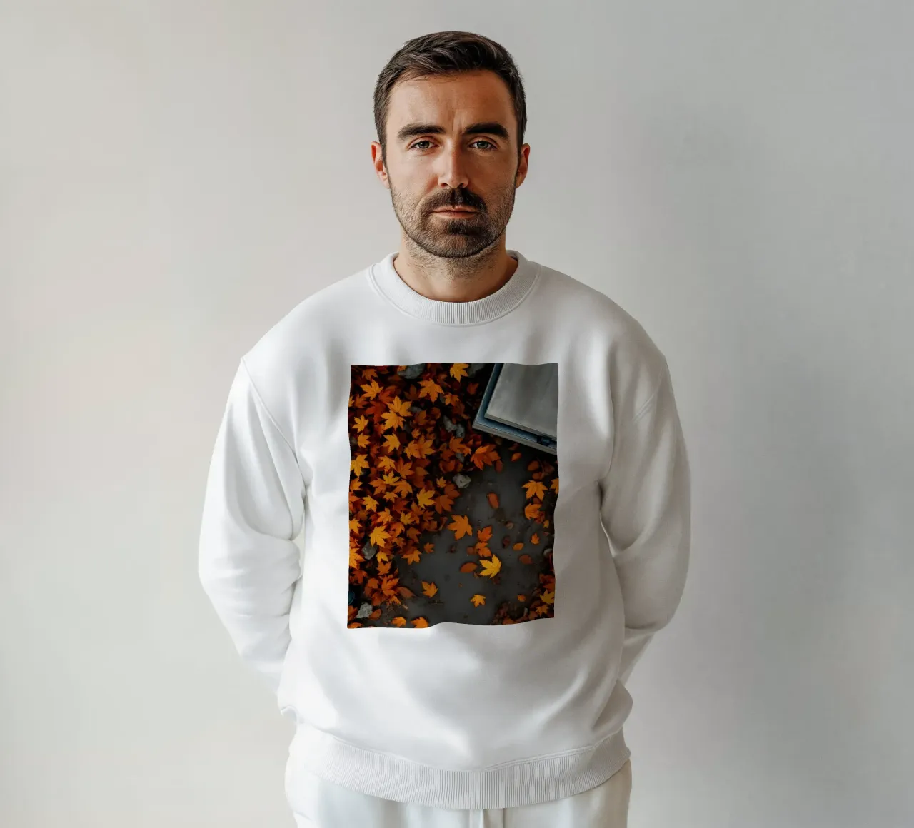 Des feuilles d'automne dorées s'éparpillent sur le sol près d'un chemin de pierre sweat de DesignDoodle