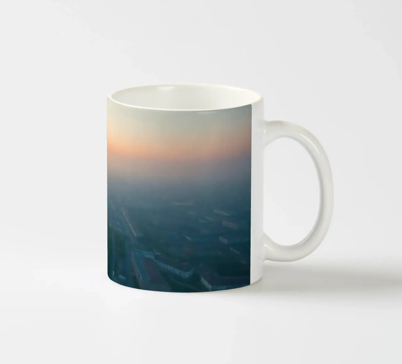 Un'alba nebbiosa su un paesaggio urbano dai tenui colori pastello tazza in ceramica da DesignDoodle