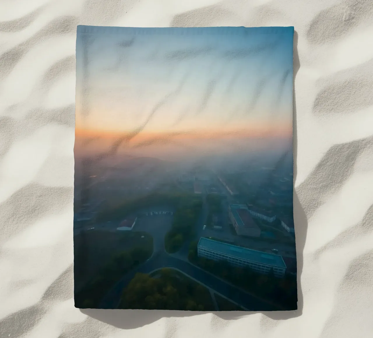 Un'alba nebbiosa su un paesaggio urbano dai tenui colori pastello telo mare da DesignDoodle