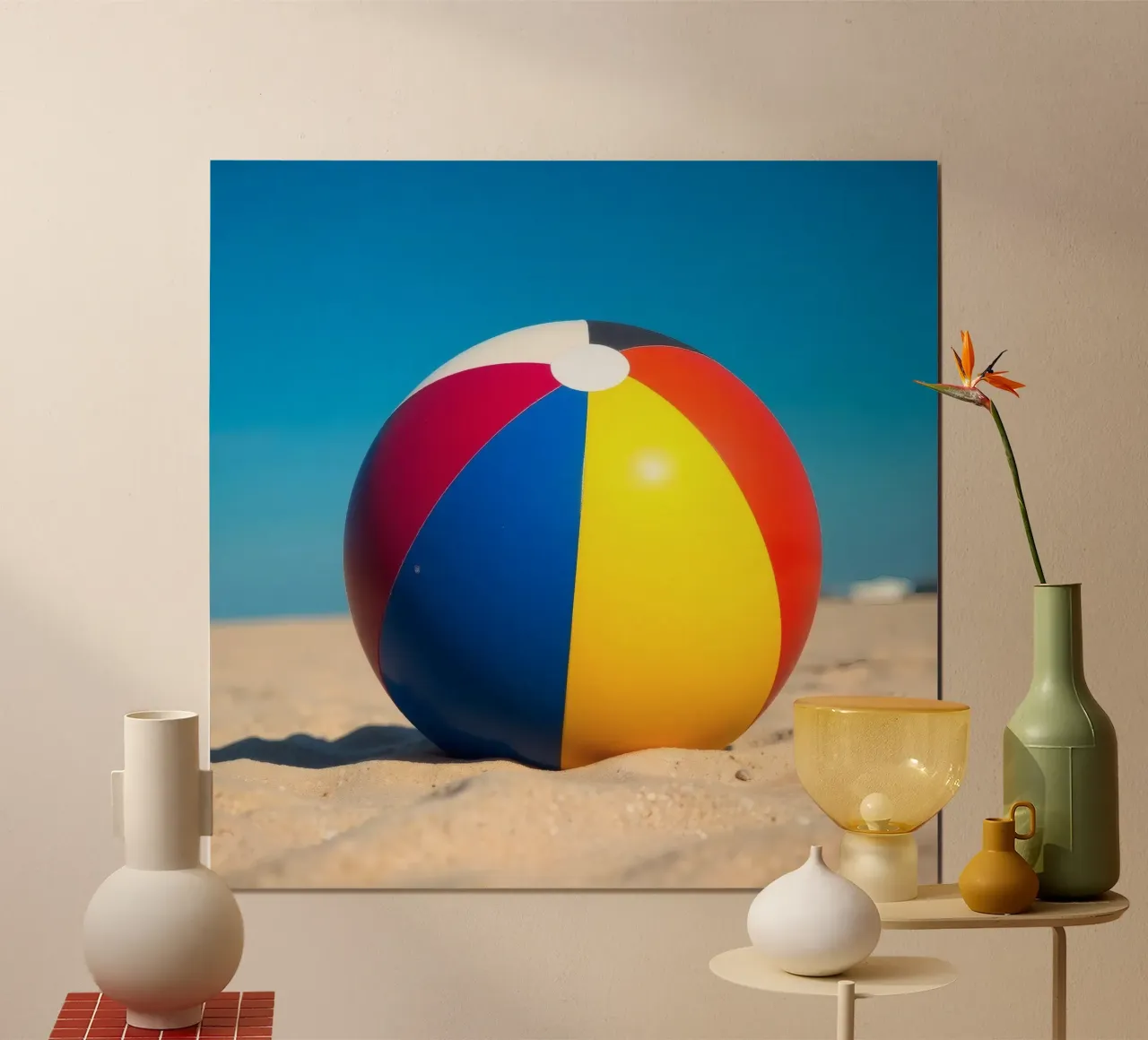un ballon de plage est posé sur un rivage sablonneux sous un ciel bleu éclatant. poster de DesignDoodle