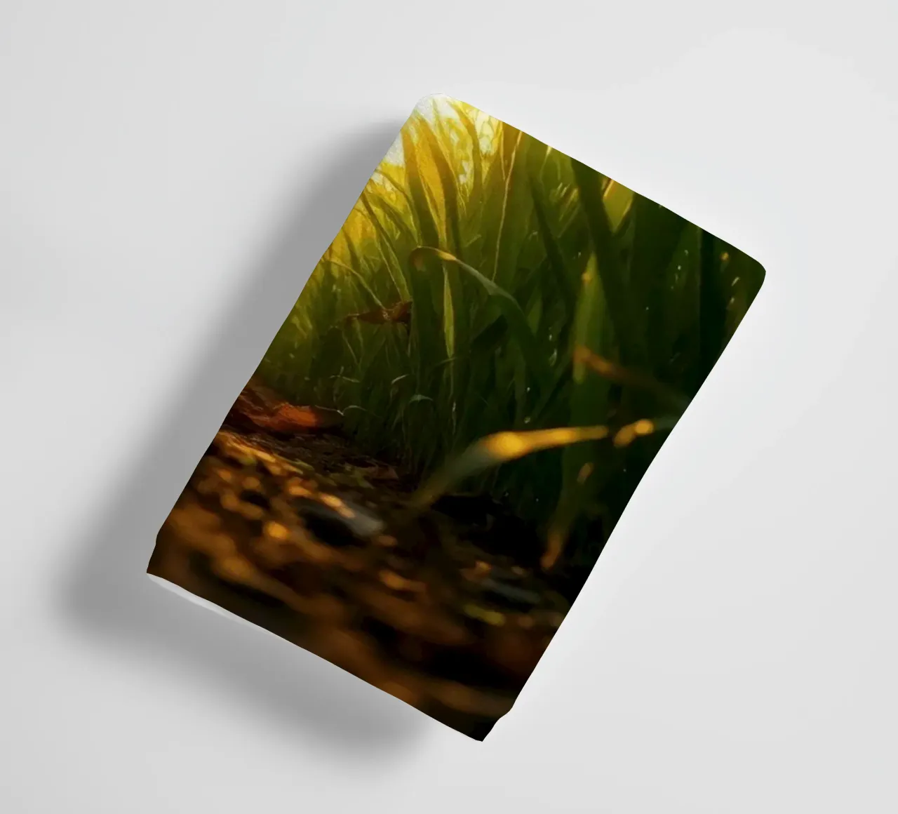 Sunlight filters through tall grass in a calm field towel by DesignDoodle