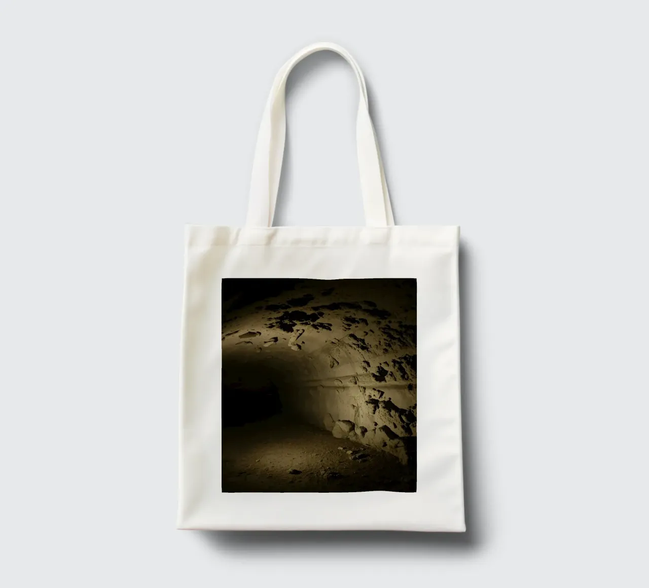 Un tunnel buio e misterioso con pareti rocciose illuminate borsa in juta da DesignDoodle
