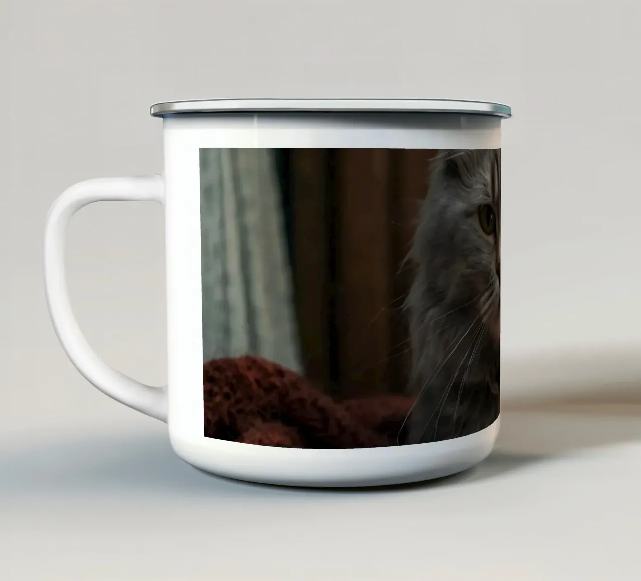 Un soffice gatto grigio riposa pacificamente su una coperta accogliente tazza in smalto da DesignDoodle