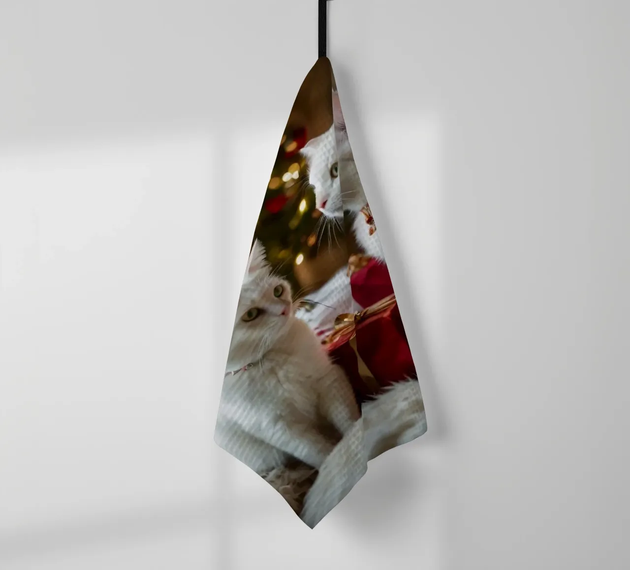 Chats blancs assis près d'un sapin de Noël entouré de cadeaux torchon de DesignDoodle