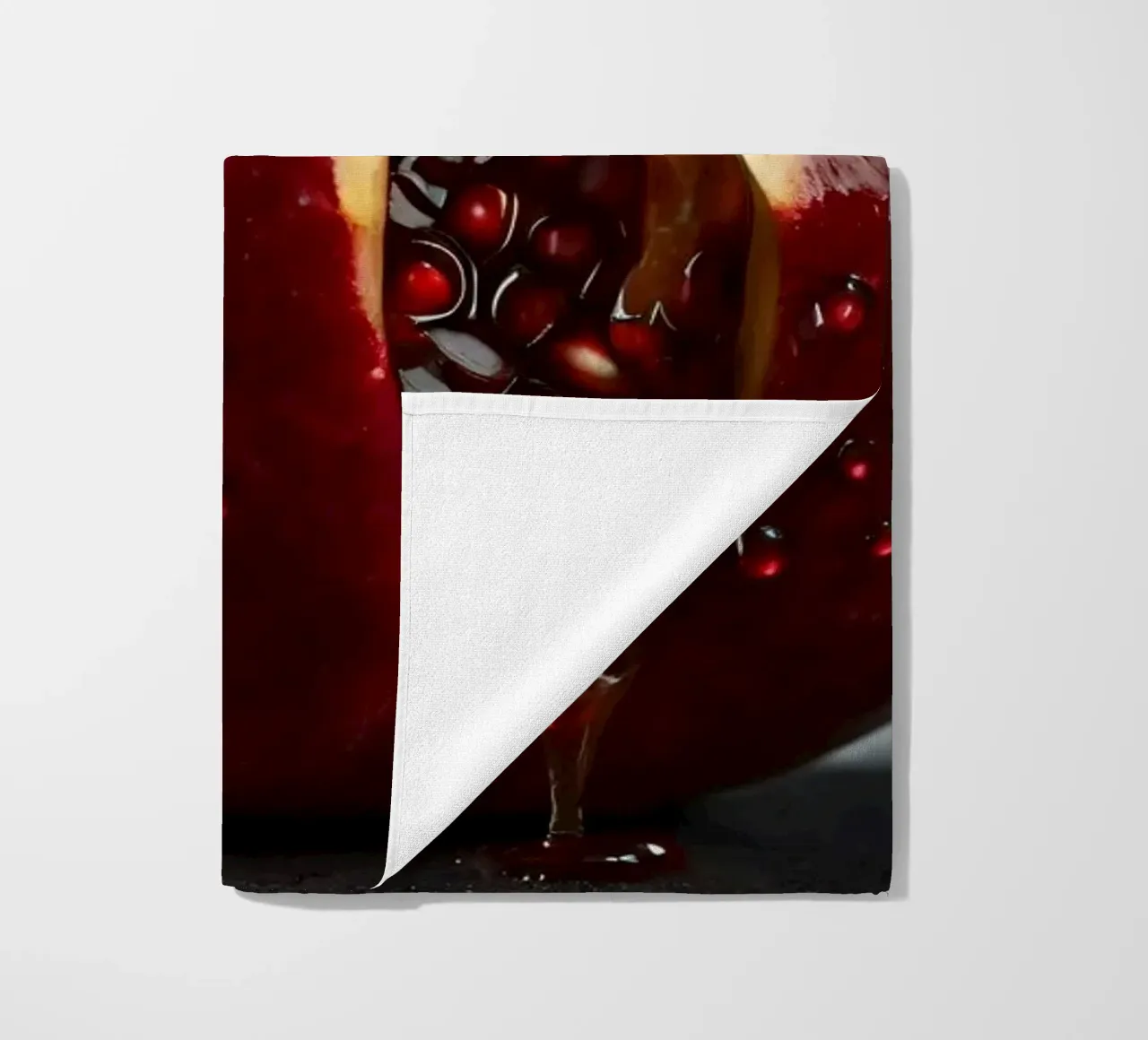 Freshly sliced pomegranate resting on a dark surface surroun beach towel by DesignDoodle
