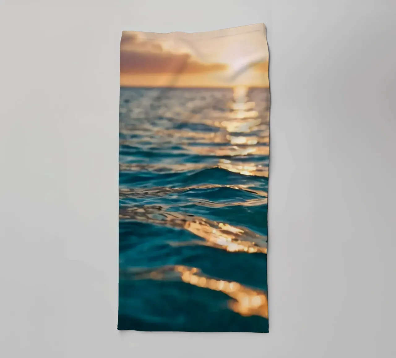Le calme onde dell'oceano riflettono un tramonto vibrante su un mare calmo. asciugamano da bagno da DesignDoodle