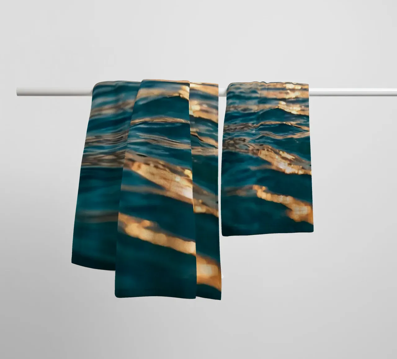 Le calme onde dell'oceano riflettono un tramonto vibrante su un mare calmo. asciugamano da bagno da DesignDoodle
