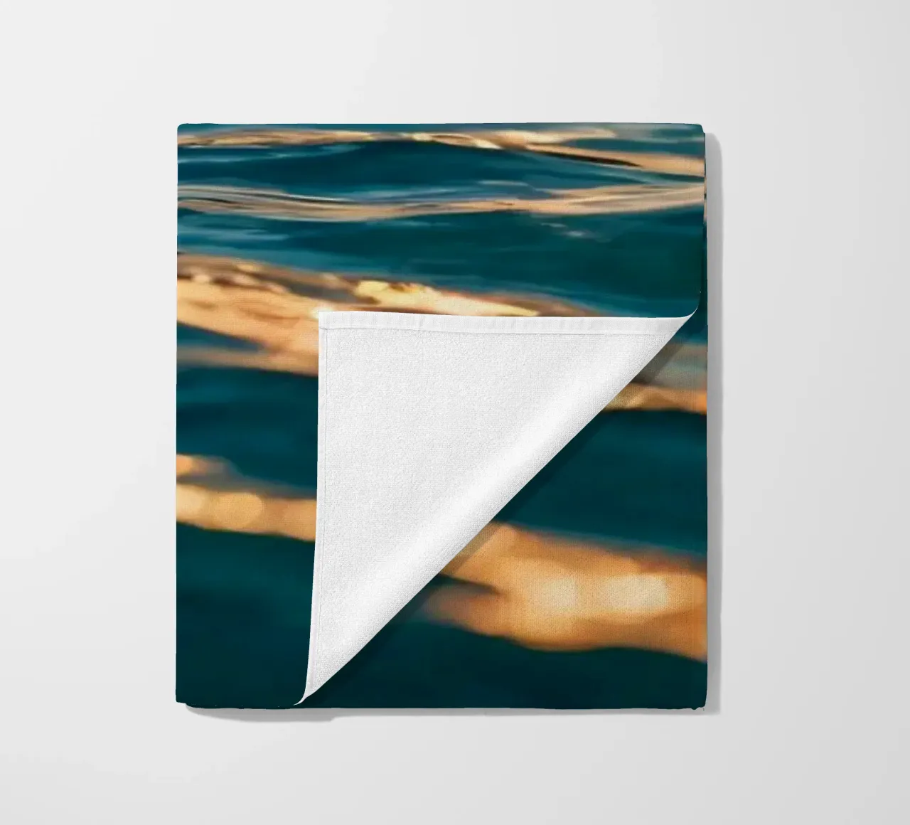 Le calme onde dell'oceano riflettono un tramonto vibrante su un mare calmo. telo mare da DesignDoodle
