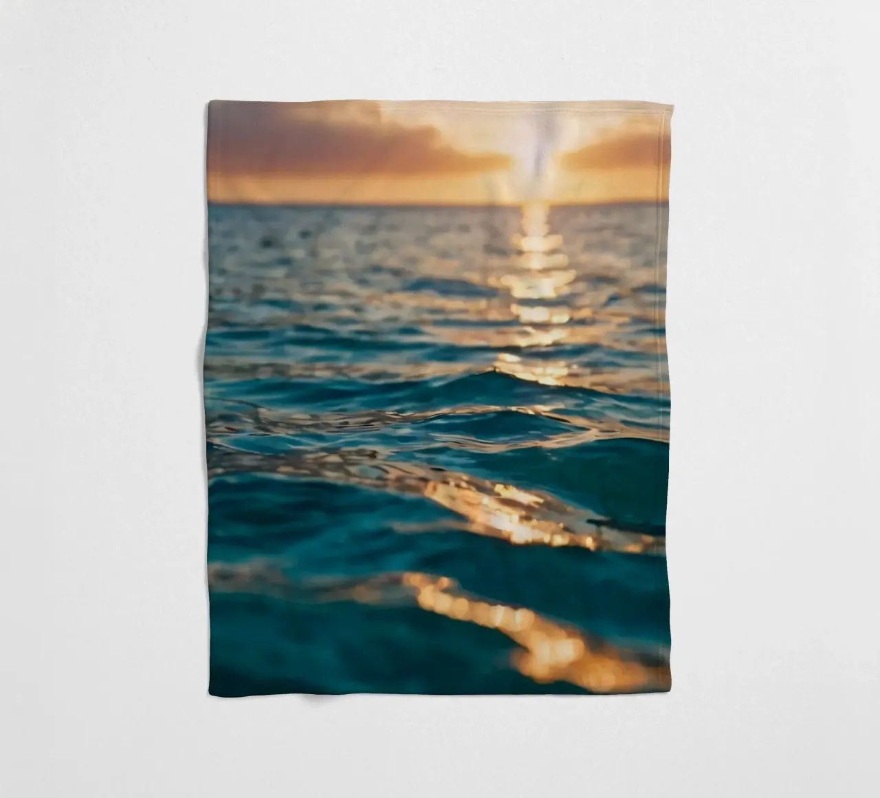 calm ocean waves reflect a vibrant sunset over calm wate fleece blanket by DesignDoodle