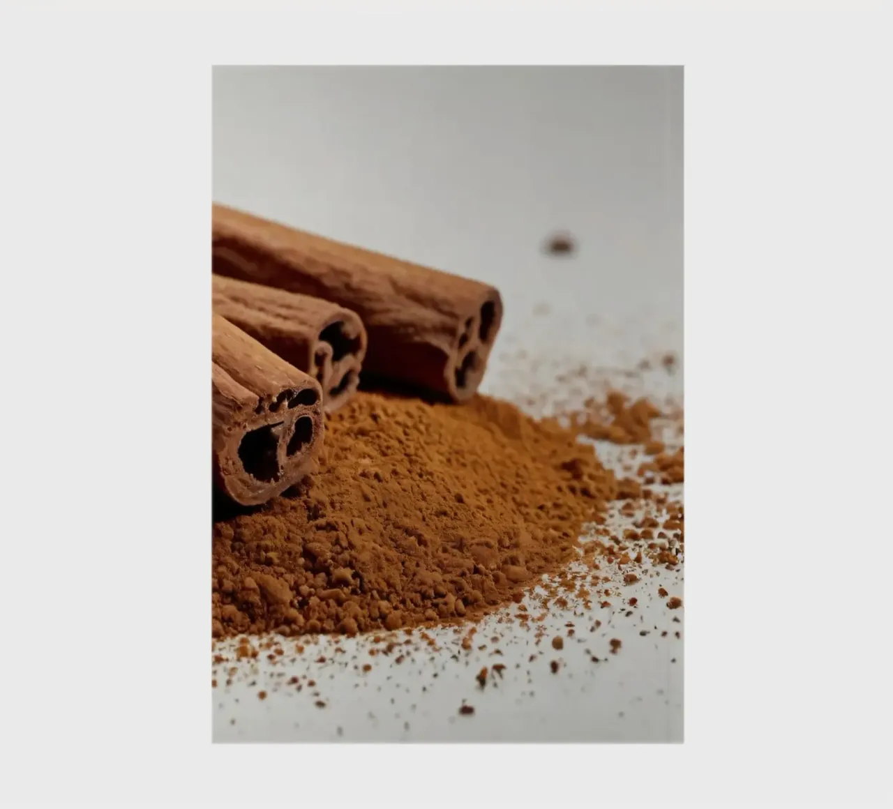 Cinnamon sticks and powder arranged neatly on white surface notebook by DesignDoodle