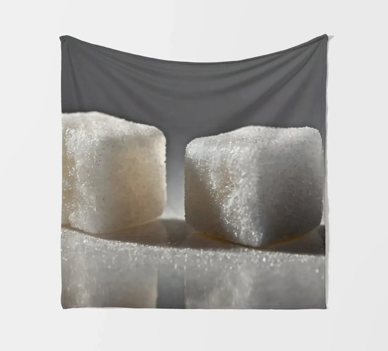 Two sugar cubes on a reflective surface with soft lighting fleece blanket by DesignDoodle