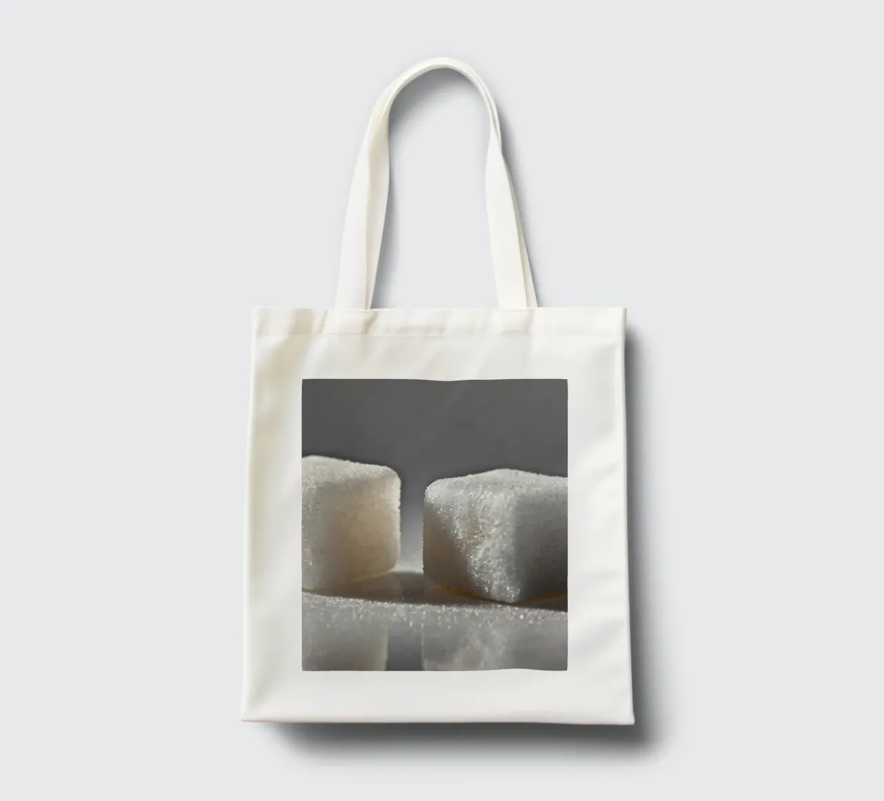Two sugar cubes on a reflective surface with soft lighting tote bag by DesignDoodle