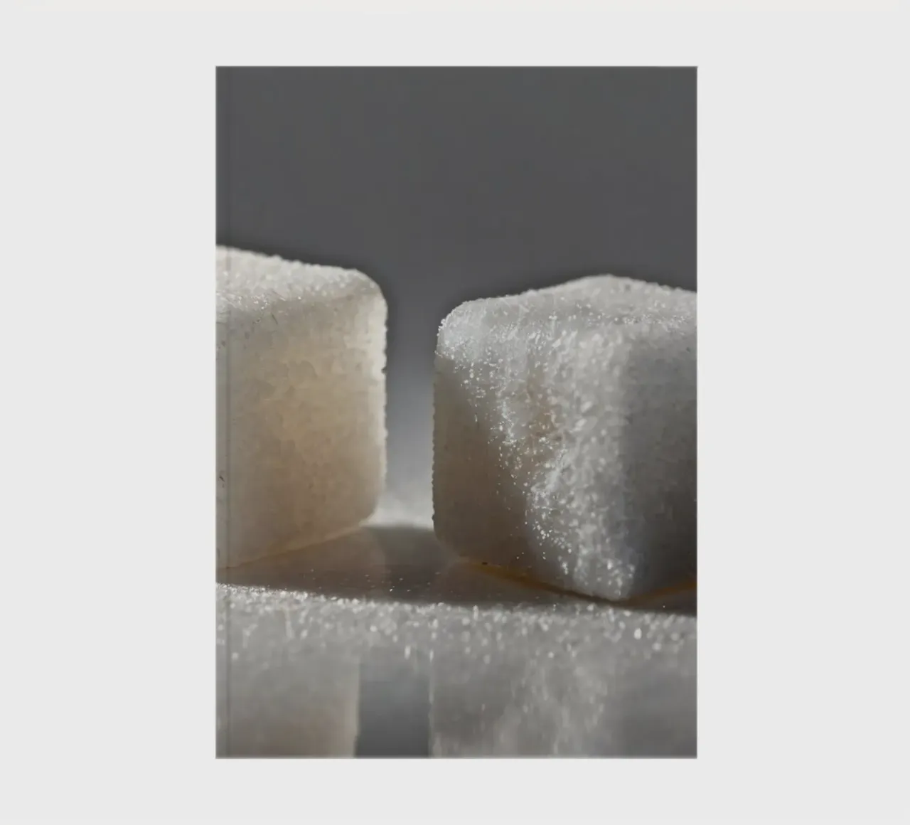 Two sugar cubes on a reflective surface with soft lighting notebook by DesignDoodle
