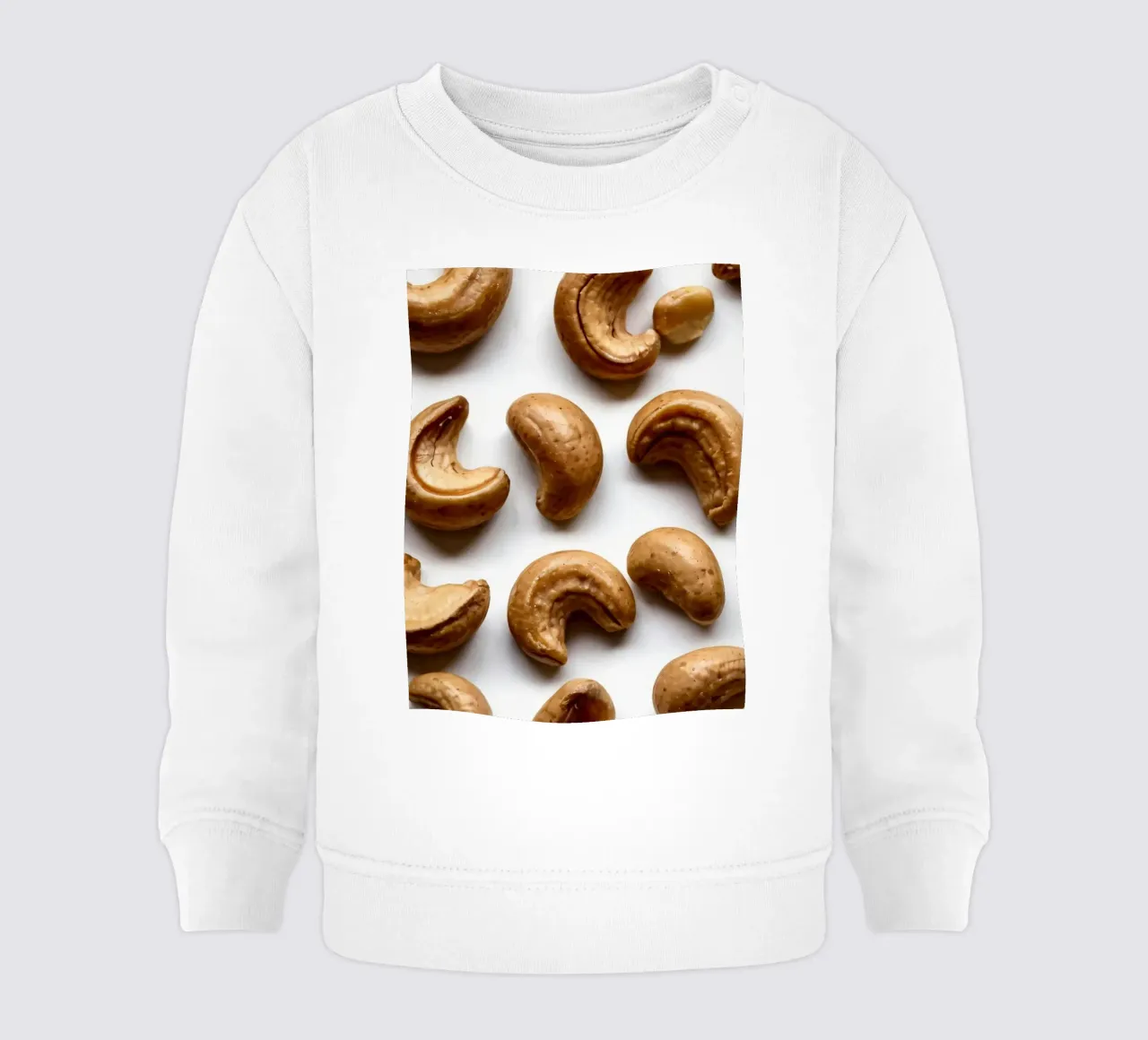 Raw cashew nuts arranged on a white surface for healthy snac baby sweatshirt by DesignDoodle