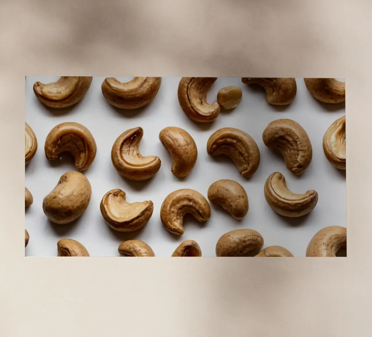 Raw cashew nuts arranged on a white surface for healthy snac backlit film by DesignDoodle