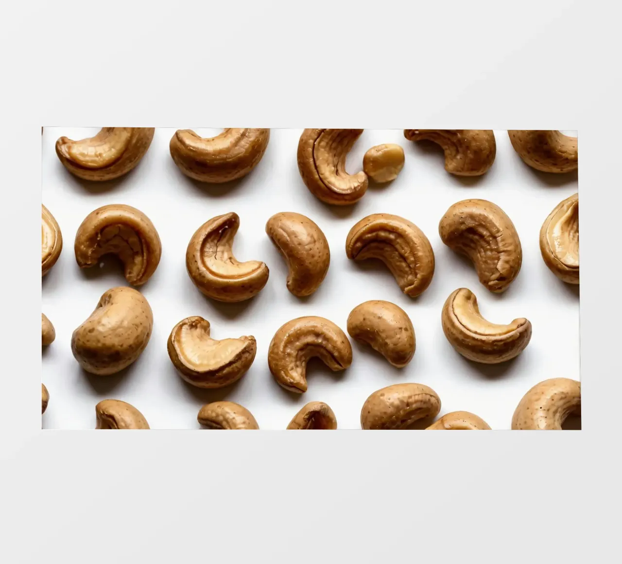 Anacardi crudi disposti su una superficie bianca per uno spuntino sano telo in pvc da DesignDoodle