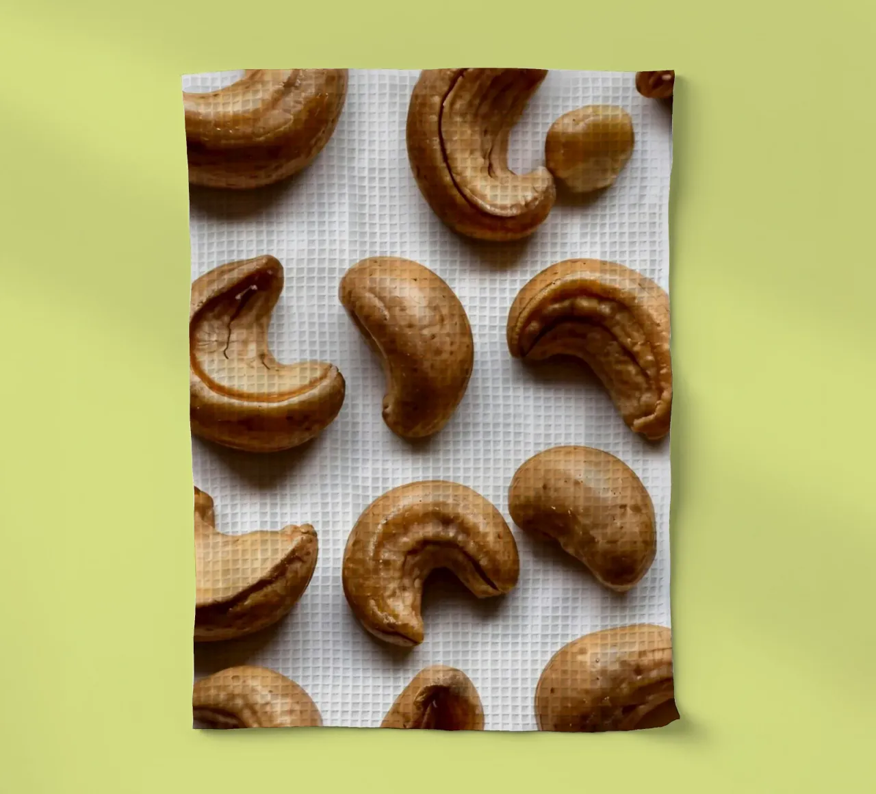 Noix de cajou crues disposées sur une surface blanche pour un en-cas sain torchon de DesignDoodle