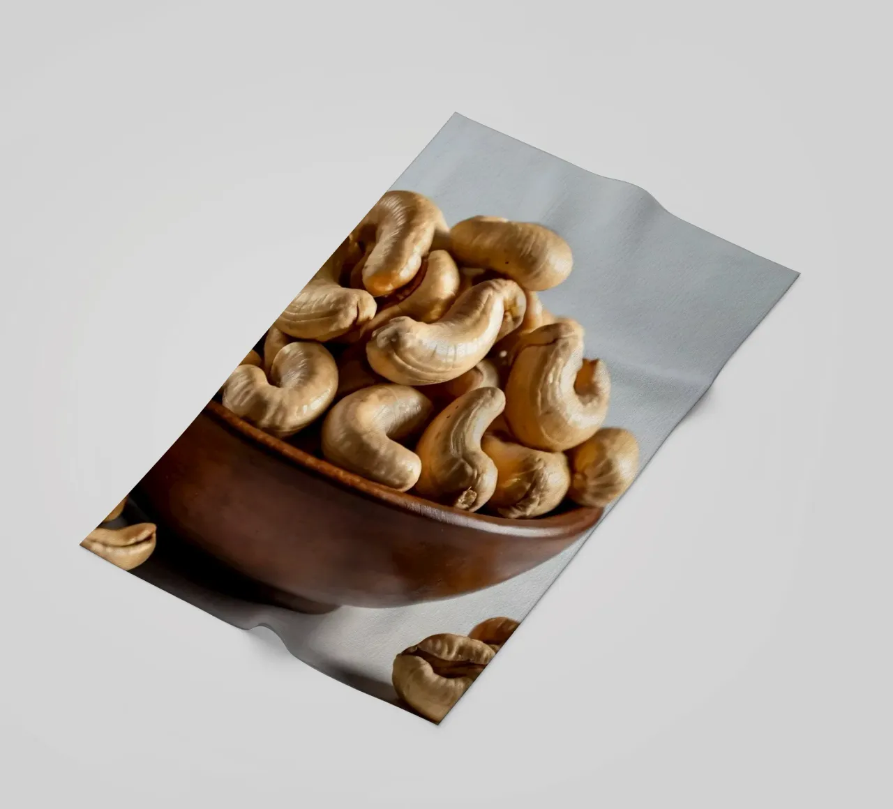 Anacardi crudi disposti su una superficie bianca per uno spuntino sano telo mare da DesignDoodle