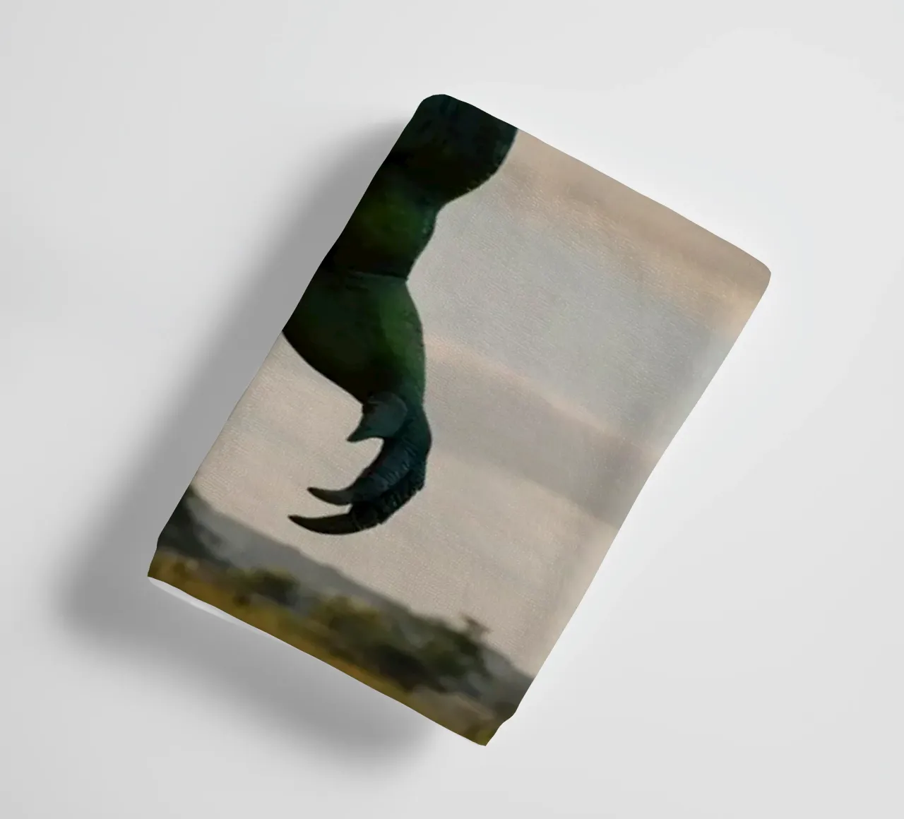 A realistic dinosaur stands in a lush landscape towel by DesignDoodle
