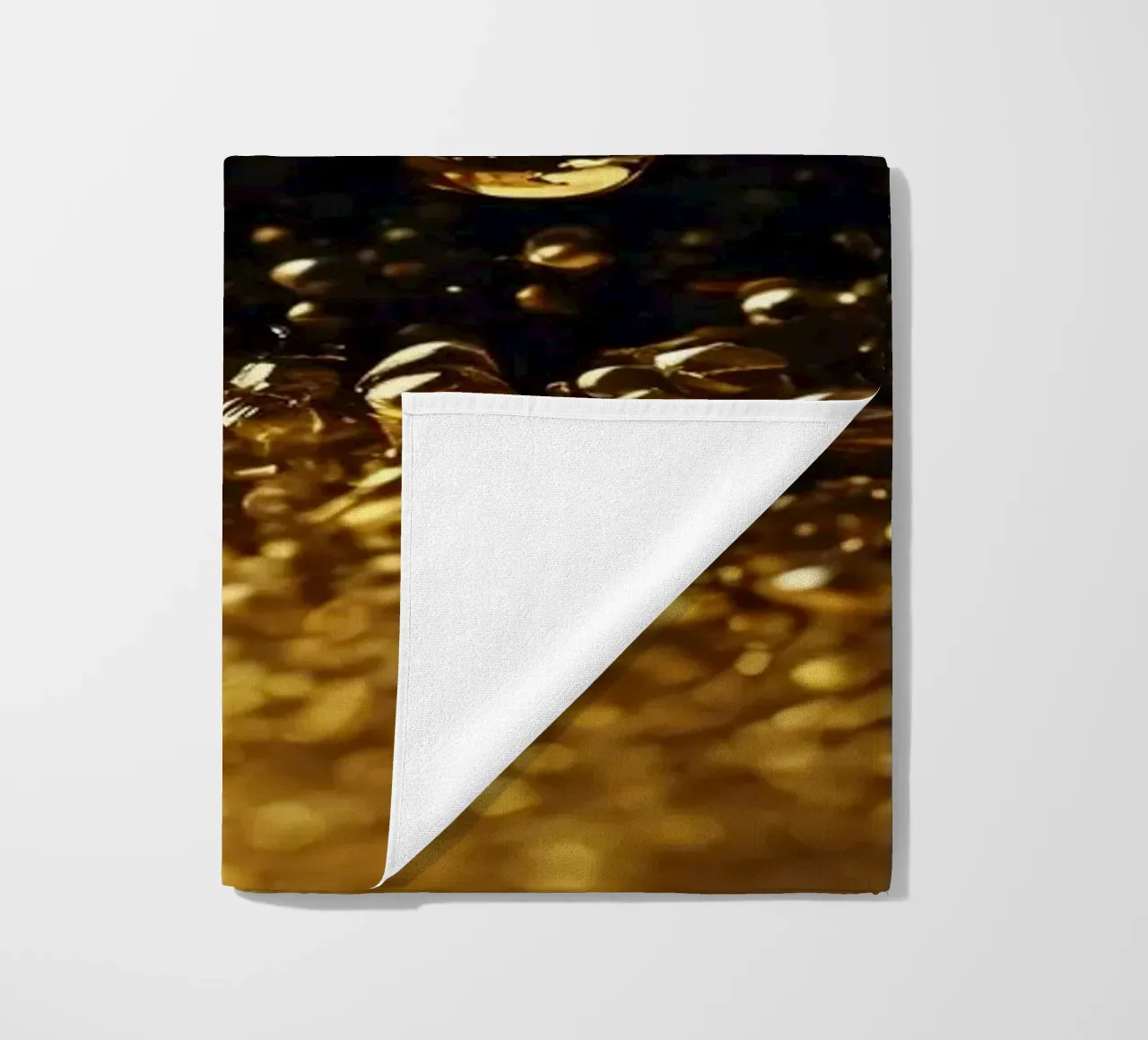 Gocce d'oro brillano su una superficie scura con un bokeh ipnotico telo mare da DesignDoodle