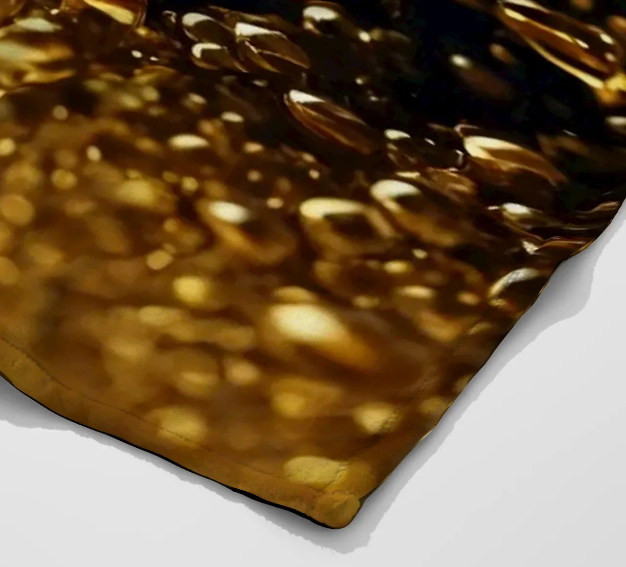 Gocce d'oro brillano su una superficie scura con un bokeh ipnotico coperta in pile da DesignDoodle