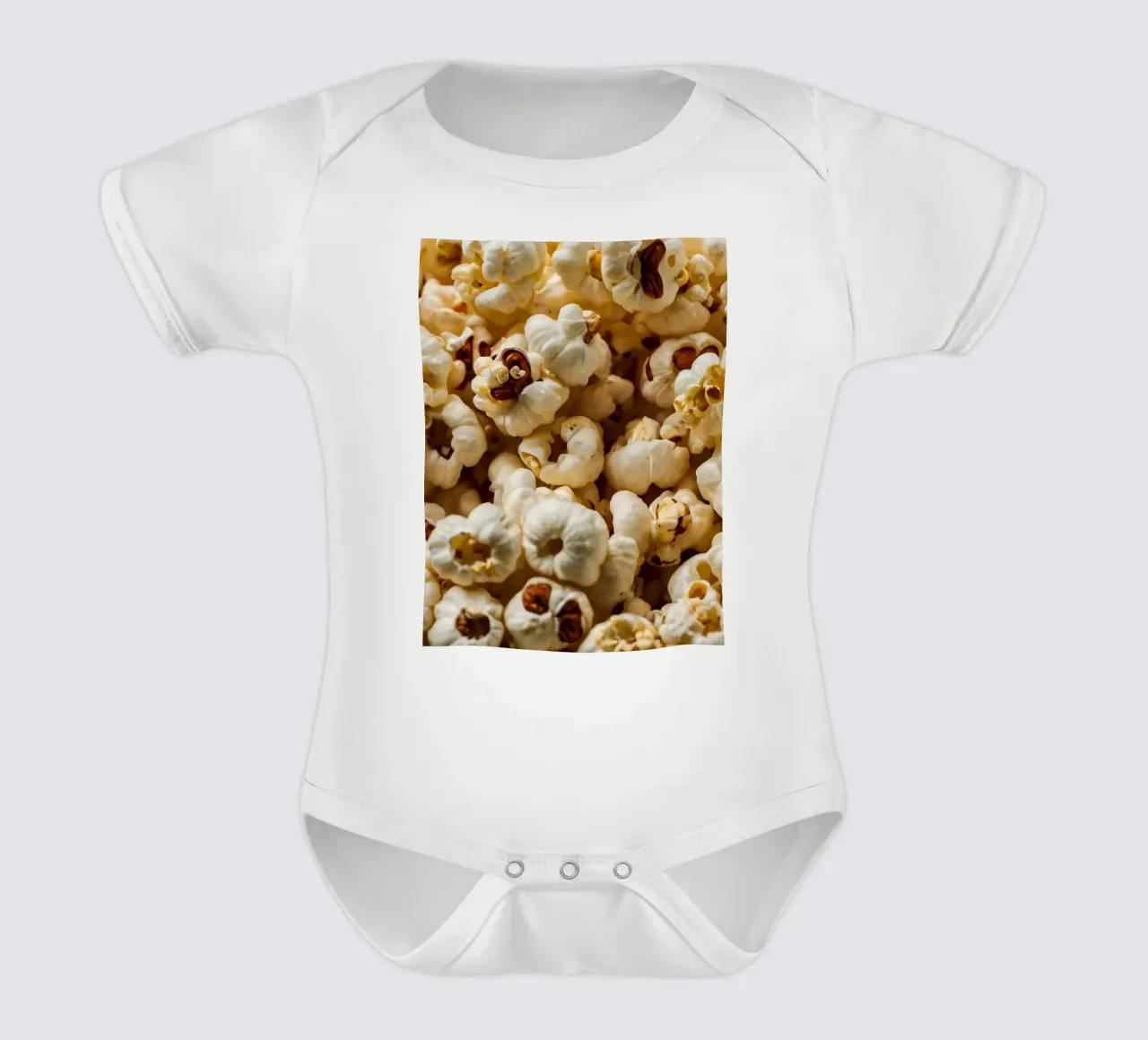 Plain popcorn kernels scattered in a bowl, ready for snackin short-sleeve baby romper by DesignDoodle