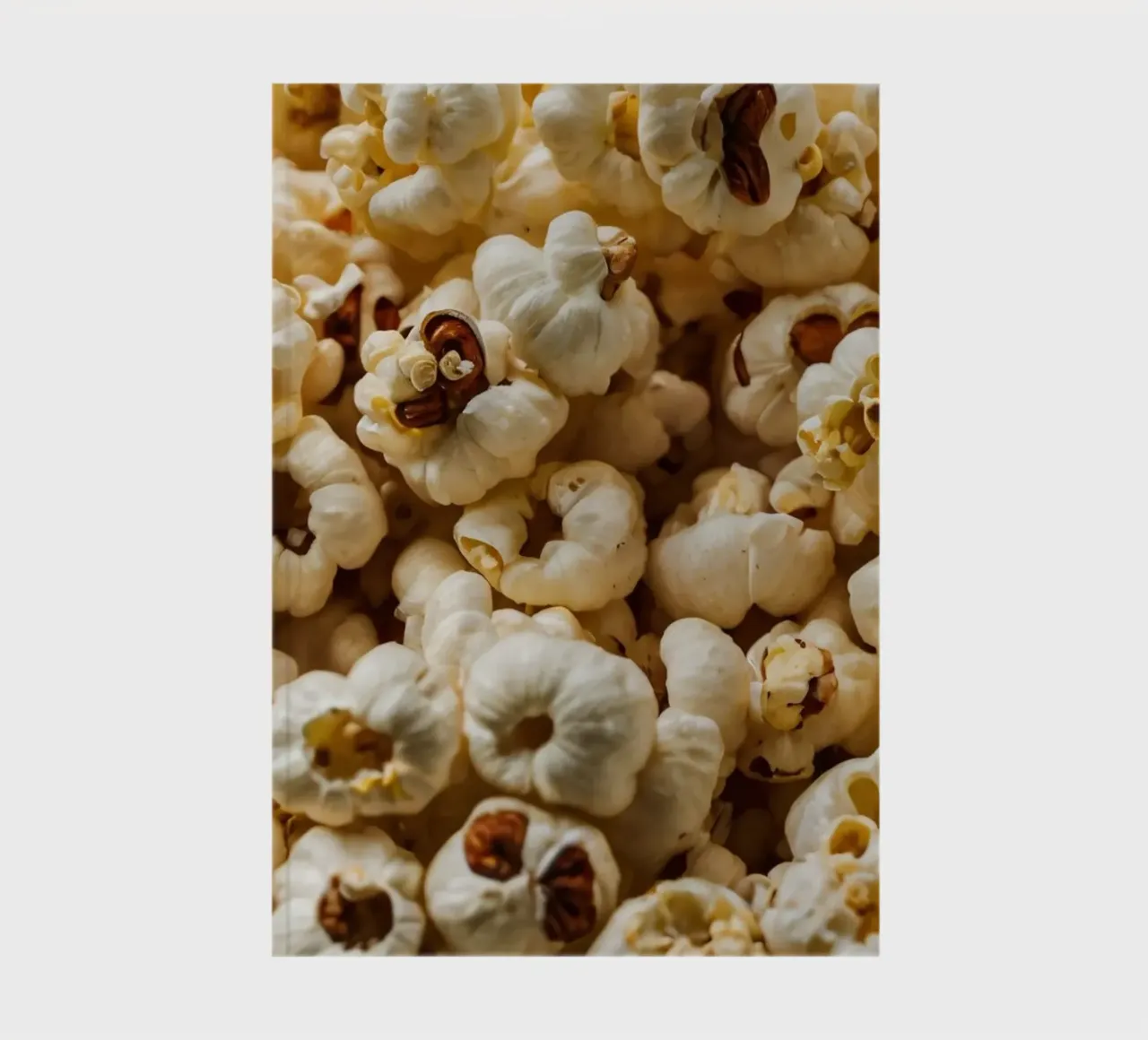Gewone popcornkorrels verspreid in een kom, klaar om te snacken notitieboek van DesignDoodle
