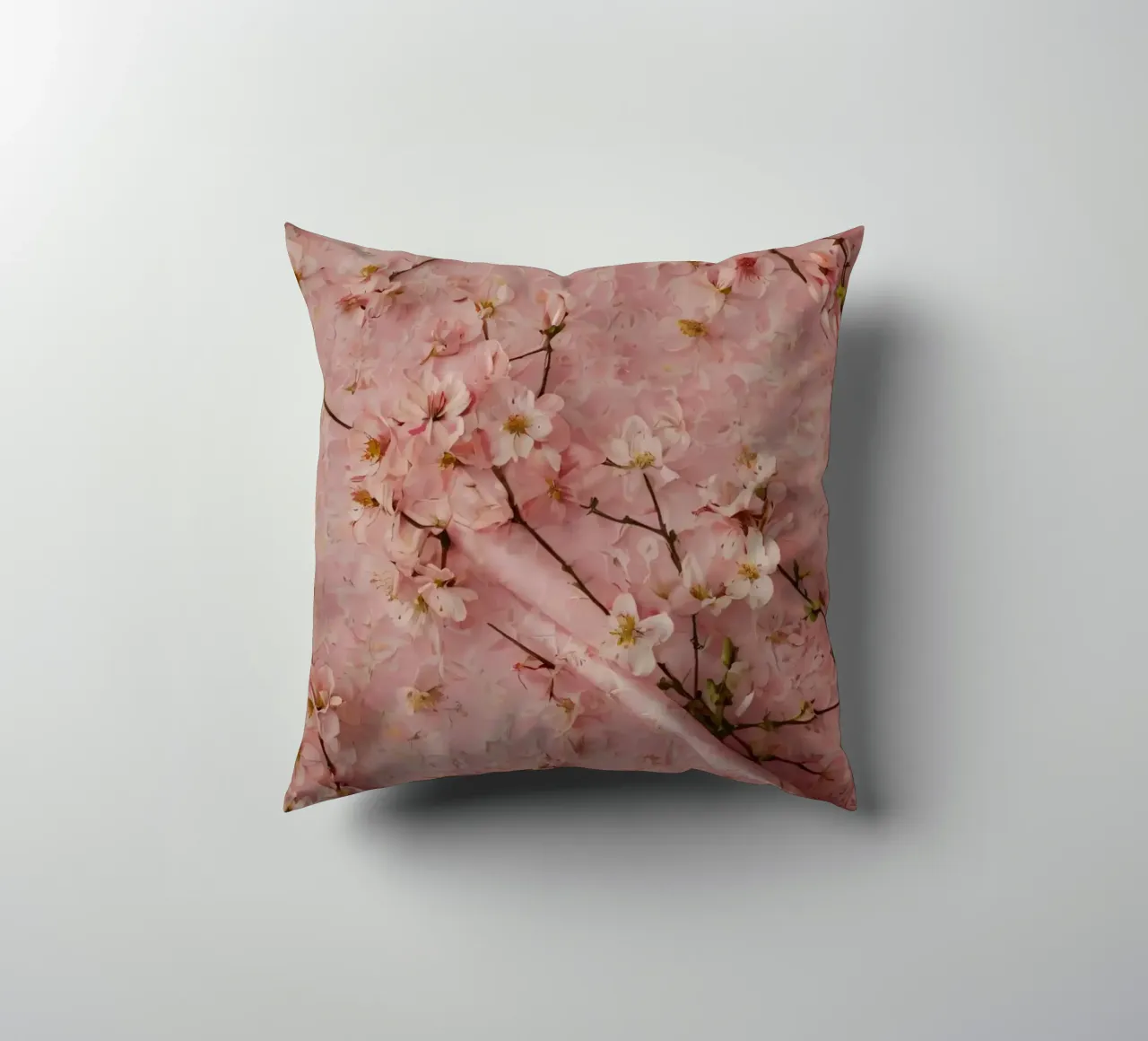 Delicati fiori di ciliegio rosa disposti su un tappeto rosa tenue cuscino da DesignDoodle