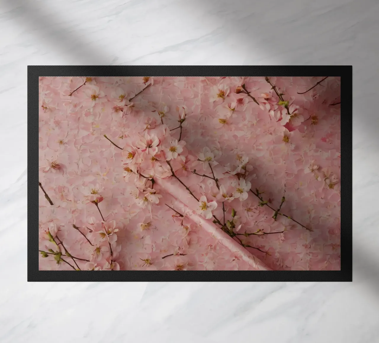 Delicati fiori di ciliegio rosa disposti su un tappeto rosa tenue zerbino da DesignDoodle