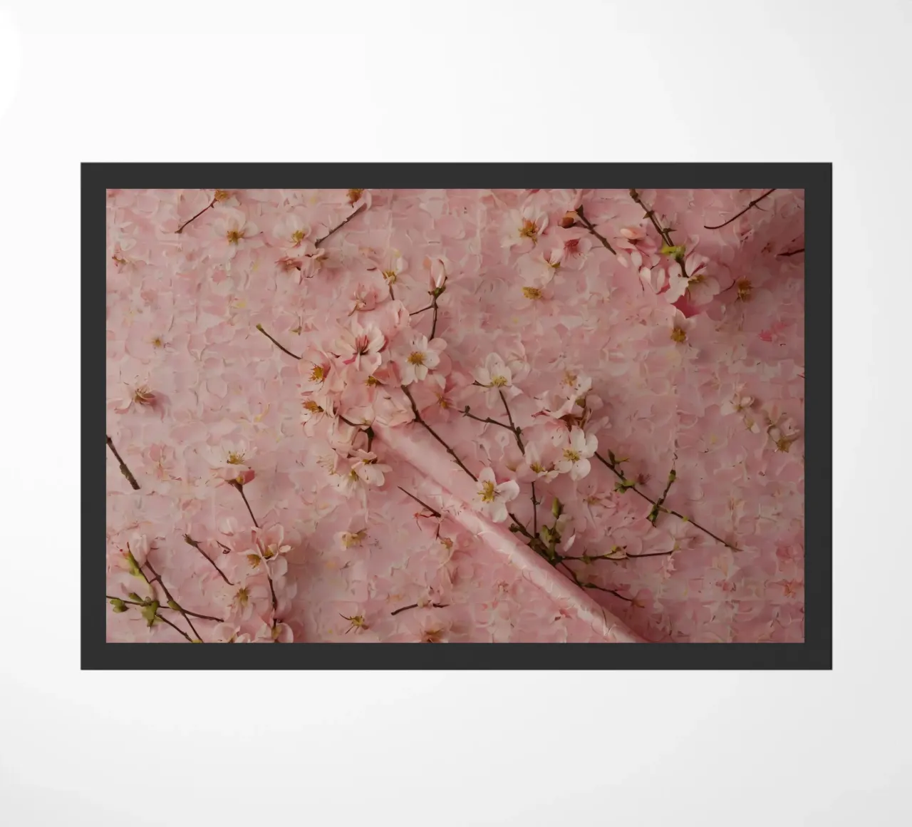 Delicati fiori di ciliegio rosa disposti su un tappeto rosa tenue zerbino da DesignDoodle