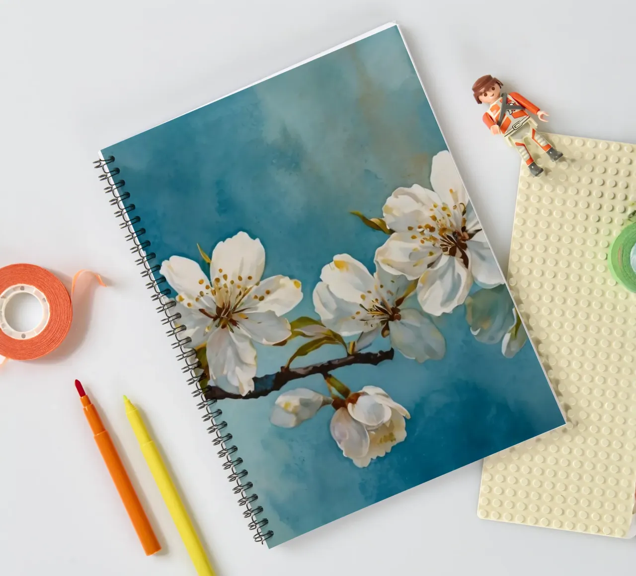 Blossoming cherry tree branch adorned with delicate white spiral notebook by DesignDoodle