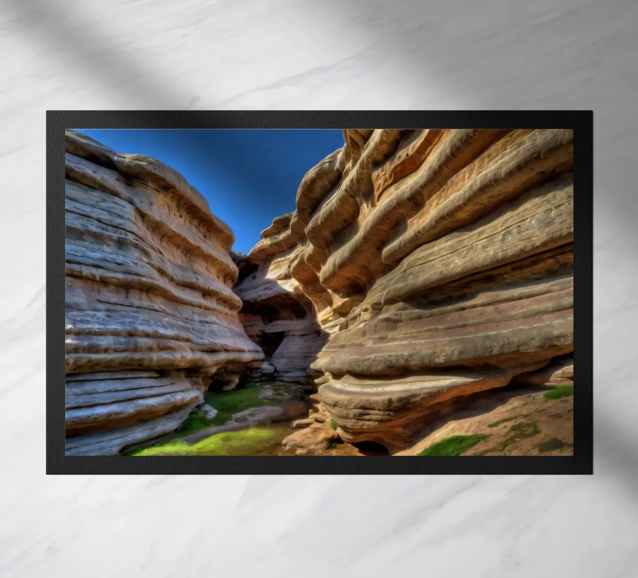 Un canyon tortuoso con formazioni rocciose lisce e stratificate zerbino da DesignDoodle