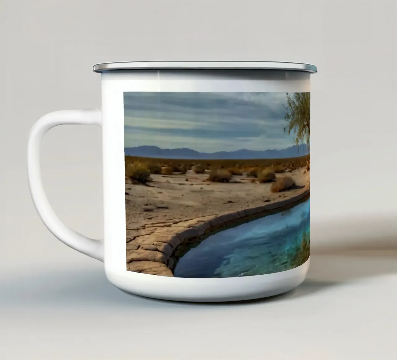 Un'oasi di pace nel deserto con un albero vivace che si riflette in un'atmosfera limpida. tazza in smalto da DesignDoodle