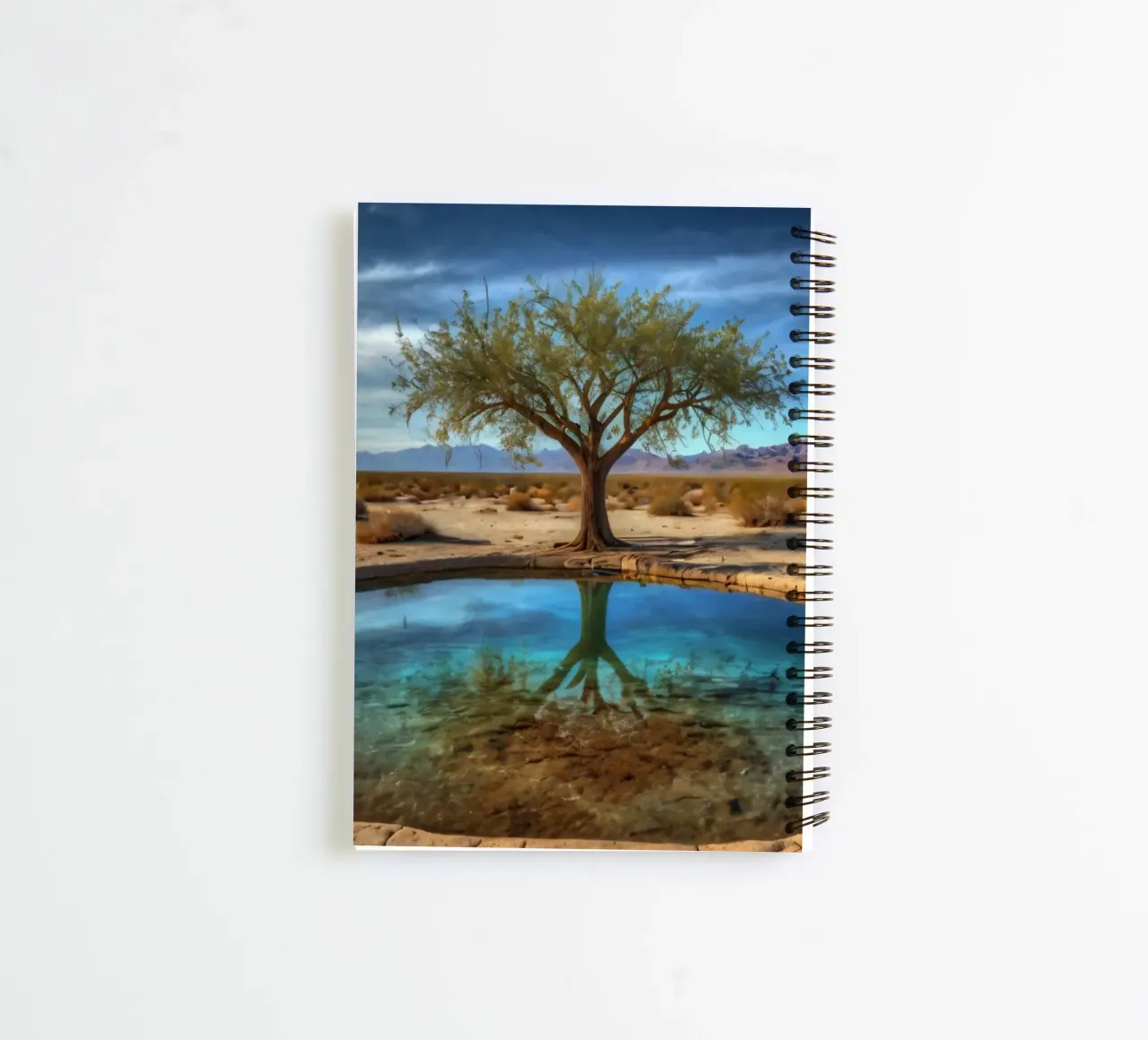 A calm desert oasis with a vibrant tree reflecting in clear spiral notebook by DesignDoodle