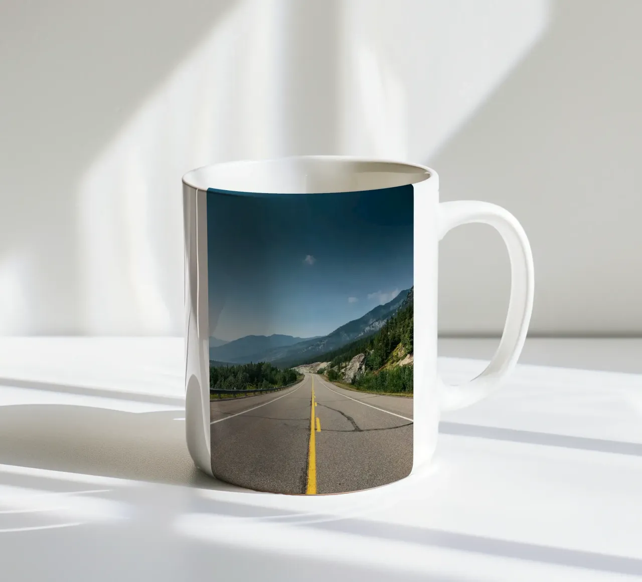road highway mountains forest trees sky clouds pavement ceramic mug by minerva santiago