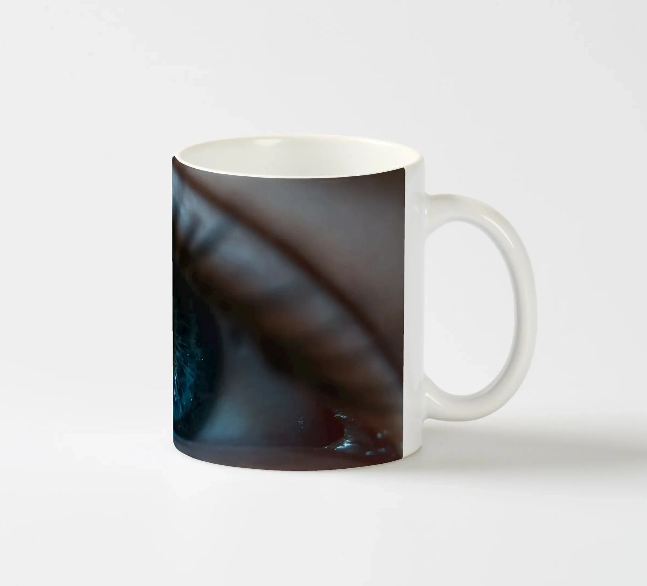 Vue rapprochée d'un œil bleu mettant en évidence des détails complexes mug en céramique de DesignDoodle