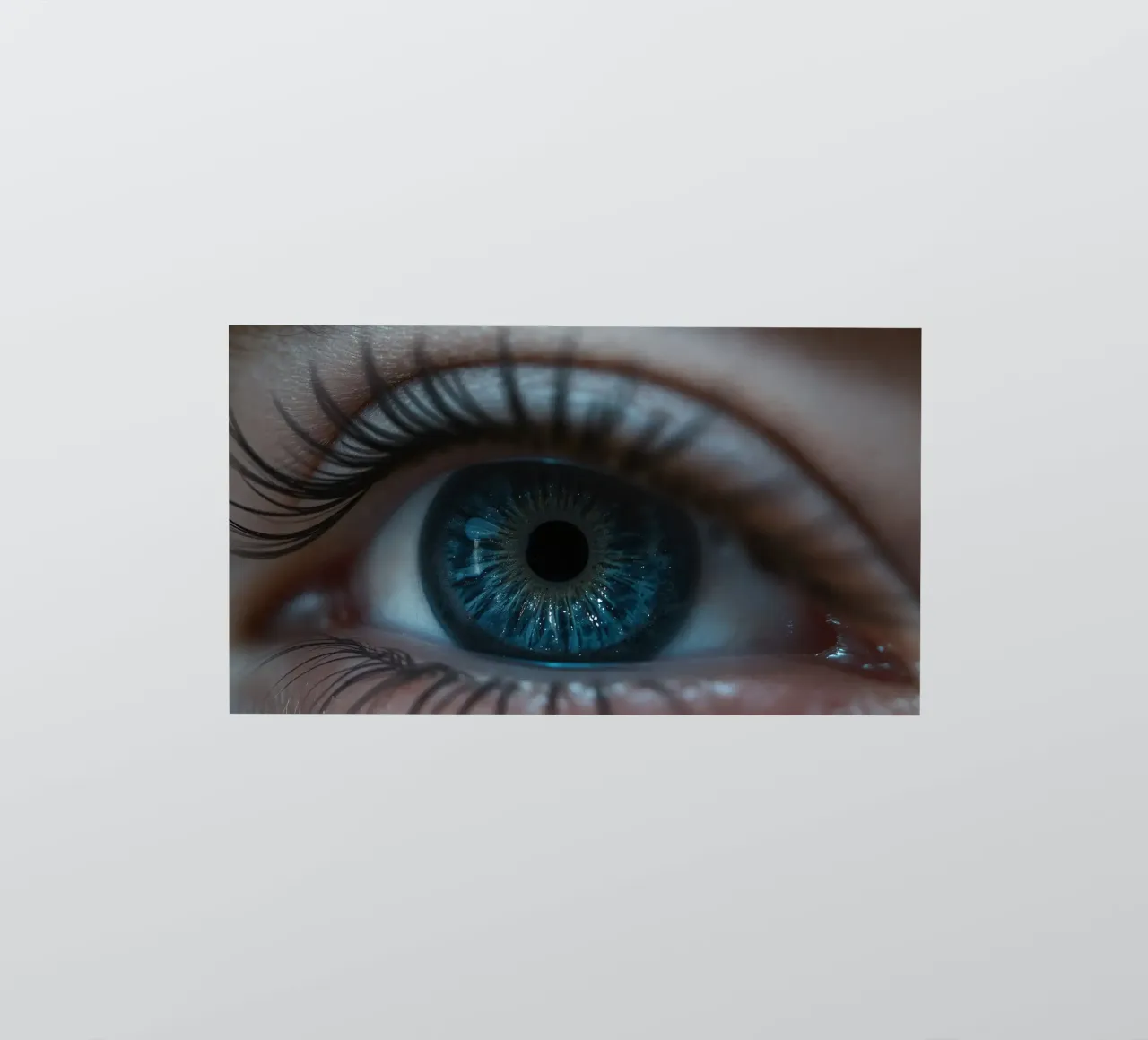 Vue rapprochée d'un œil bleu mettant en évidence des détails complexes autocollant de DesignDoodle