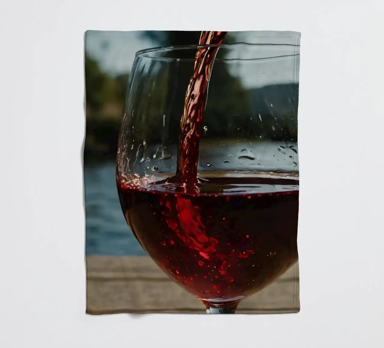 Versare del vino rosso in un bicchiere accanto a un lago tranquillo, al sole. coperta in pile da DesignDoodle