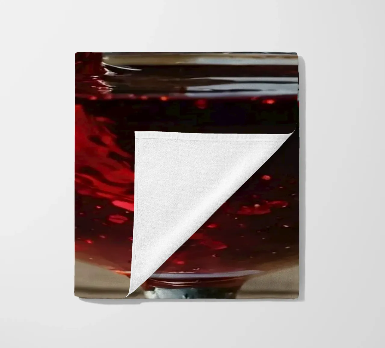 Versare del vino rosso in un bicchiere accanto a un lago tranquillo, al sole. telo mare da DesignDoodle