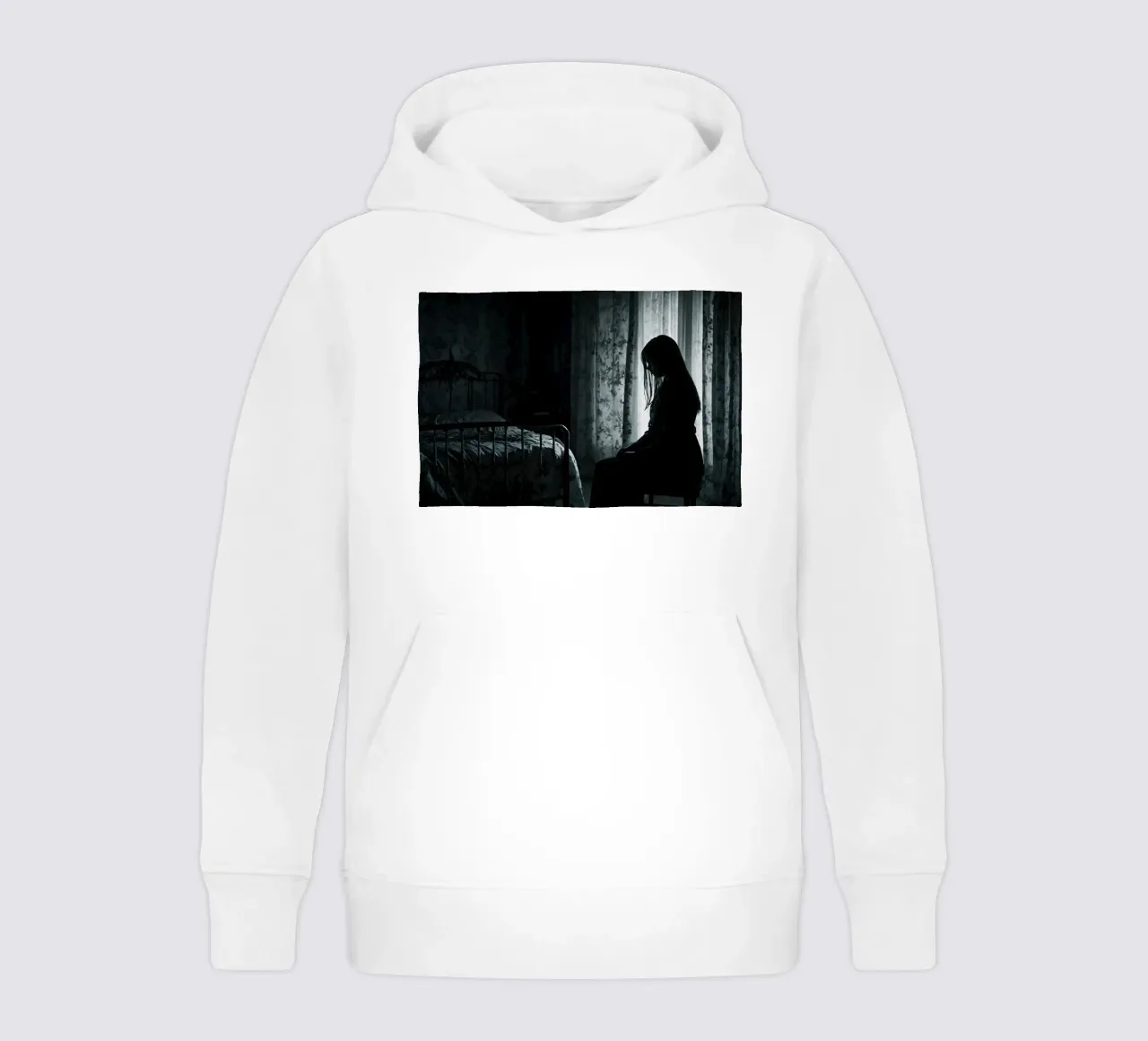 Una ragazza siede in silenzio in una stanza poco illuminata, contemplando la vita felpa bambino con cappuccio da DesignDoodle